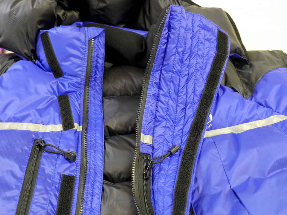Jacket showed flared over-baffle (to protect water drips from oxygen-mask freezing on zip) Jacket showed flared over-baffle (to protect water drips from oxygen-mask freezing on zip)